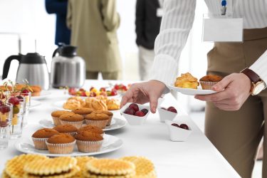 Woman taking snack during coffee break, closeup